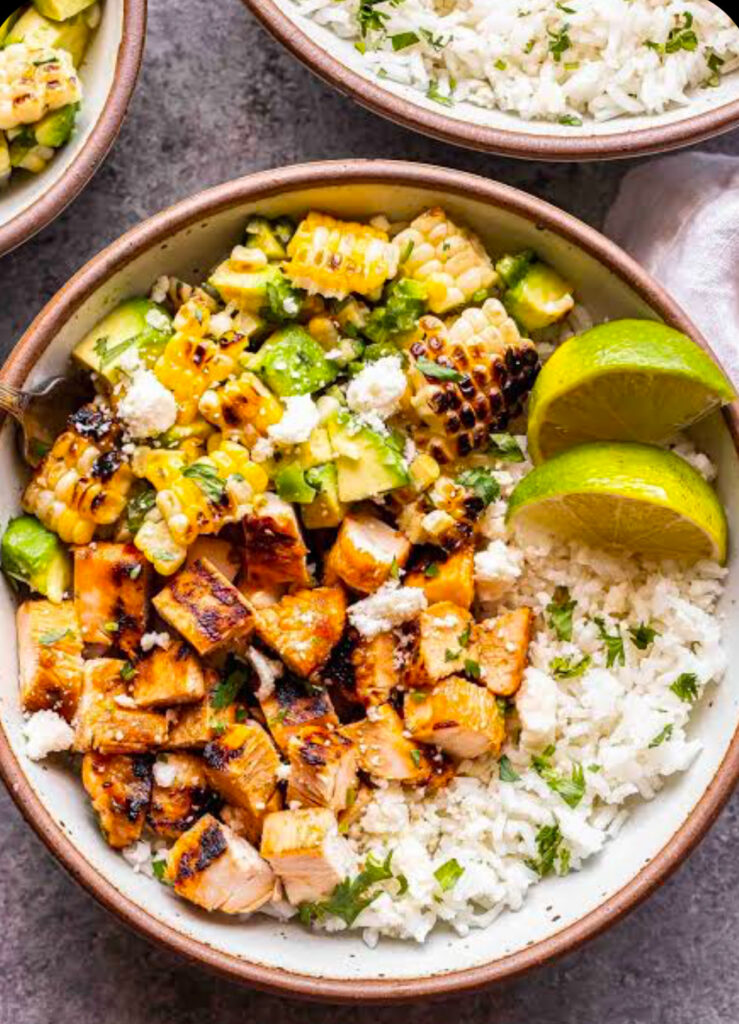 A vibrant, freshly cooked smoky chipotle chicken rice bowl with seared diced chicken and scrambled eggs.